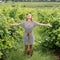 Woman walking in a vineyard, looking to the sky, arms outstretched