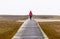 Woman walking on a walkway through marshland on a foggy autumn day