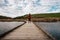 Woman walking on wooden walkway on Peka Peka Wetlands, Hawke`s Bay, New Zealand