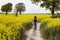 Woman walking through a yellow rapeseed field