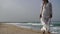 A woman walks along the beach. Slender female legs and feet walking on the sand on a sea water beach on a sandy beach