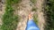 Woman walks along dirt path on a sunny summer day