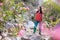 A woman walks in a beautiful park with oleander flowers