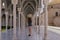 Woman walks down the colonnade of old building. Tourist visits the ancient sights