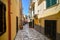 A woman walks down a colorful narrow alley towards a cafe in the Italian city of Brindisi Italy, in the Puglia region