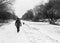 A woman walks down the frozen canal towpath