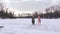 Woman walks on the ice in a bathing suit and barefoot.