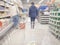 woman walks inside in supermarket. Abstract blurred background