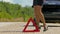 A woman walks next to a warning triangle