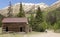 A Woman Walks by an Old Cabin on the Alpine Loop Backcountry Byway