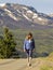 A Woman Walks a Paved Section of the Alpine Loop Backcountry Byway