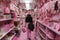 A woman walks through a pink store with pink stuff on the walls. AI generation