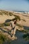 a woman walks on the sand away from the sea in windy weather enjoying the pleasant weather