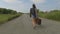 Woman walks with a suitcase on the road