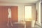 Woman walks in white bathroom with tub and cabinet