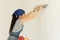 Woman wallpapering a wall