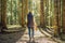 A woman in warm clothes enjoys a walk in a pine forest