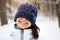 A woman with a warm knitted hat pulled over her eyes smiles and enjoys the snow, the spring sun. Outdoor activities, seasonality,