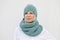 Woman in warm turquoise knitted hat and snood.