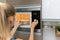 Woman warm up the food in microwave oven at home