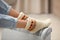 Woman warming feet on electric heater at home