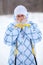 Woman warming frozen hands with ski poles in winter