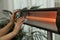 Woman warming hands near electric infrared heater indoors, closeup