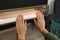 Woman warming hands near electric infrared heater indoors, closeup