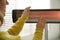 Woman warming hands near electric infrared heater indoors, closeup