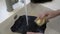 A woman washes a black plate under a stream of water in the kitchen sink. Homework. Extreme close-up. Faceless. Concept