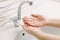 Woman washes her hands by surgical hand washing method.