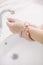 Woman washes her hands by surgical hand washing method.