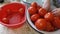 Woman washes ripe red tomatoes from mud in water