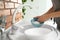 Woman washing dishes in kitchen sink, closeup view.