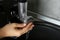 Woman washing electric meat grinder in kitchen sink indoors, closeup. Space for text