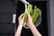 Woman washing fresh raw asparagus over sink. Top view