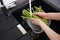 Woman washing fresh raw asparagus over sink. Top view