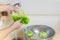 Woman washing lettuce and fruit in kitchen sink with running water.