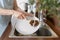 Woman washing plate using coconut wooden brush