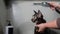 Woman washing a tabby gray cat in a grooming salon.