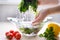 Woman washing in water in sink green kale cabbage leaves in kitchen, organic healthy food Super Slow Motion Shot of