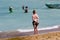 A woman watches a fisherwoman on a beach in Bali