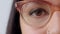 Woman watching or gazing with trendy optometry vision glasses. Closeup of eyes looking forward while wearing optician