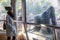 Woman watching huge silverback gorilla male behind glass in Biopark zoo in Valencia, Spain