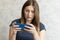 Woman watching shocking video online on her mobile phone. Young girl looking at phone seeing bad news or photos. Girl pleasantly