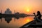 Woman watching sunset over Taj Mahal from a boat, Agra, India