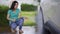 Woman water spray her car wheel with water tube washing it