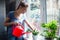 Woman watering flowers at home