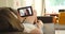 Woman, wave and relax with video call on sofa in home on digital tech device. Online communication,talking on smartphone