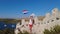 Woman waving a Croatian flag on Wall of Ostrica